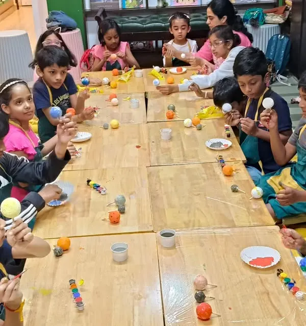 Students are busy painting the planets for their solar system models. This project combines science with art, making learning about astronomy fun and memorable.