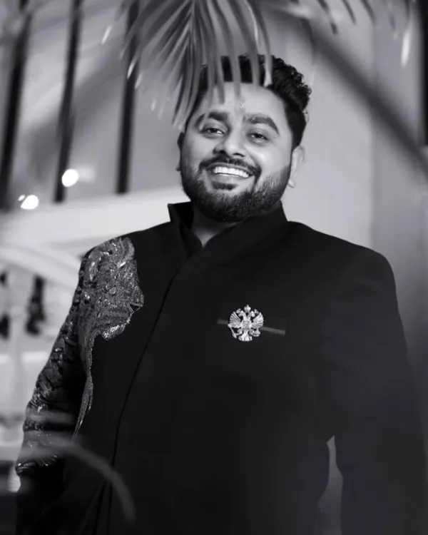 A timeless black and white portrait of the groom, Rajat, his confident smile captured perfectly. This shot shows his charm and readiness for the big day.