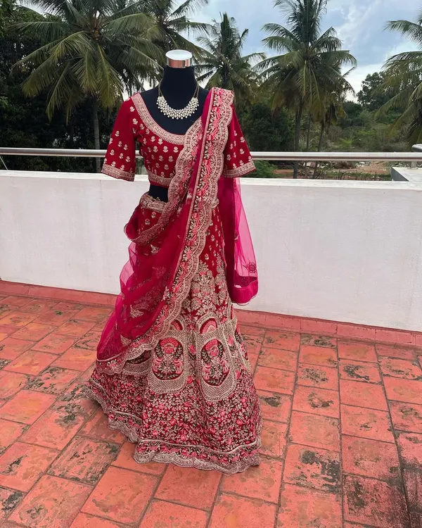 This is a glimpse of one of my premium bridal lehengas available for rent. The intricate velvet embroidery and rich magenta color make it a luxurious choice for a bride on her wedding day.