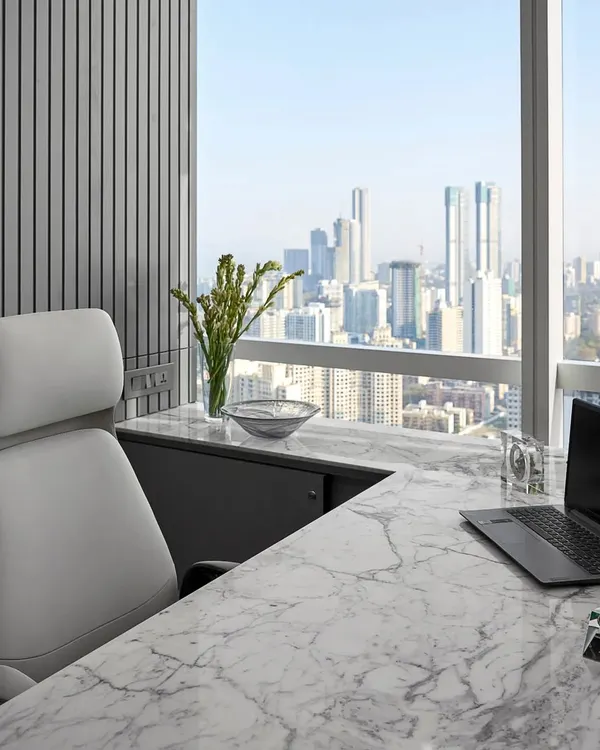 An office with a view. This executive cabin features a clean, white marble desk and a comfortable, ergonomic chair, all positioned to take full advantage of the panoramic city skyline. It’s a space designed for focus and inspiration.