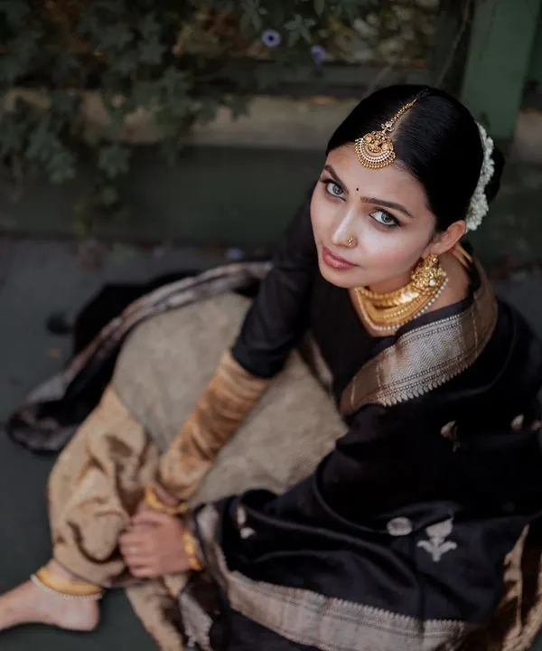 We captured this high-angle shot to emphasize the beautiful drape and texture of this heritage lehenga. The moody, natural lighting adds a touch of drama, creating an editorial feel perfect for a high-fashion lookbook in Bangalore. This is how we tell a story with clothing.