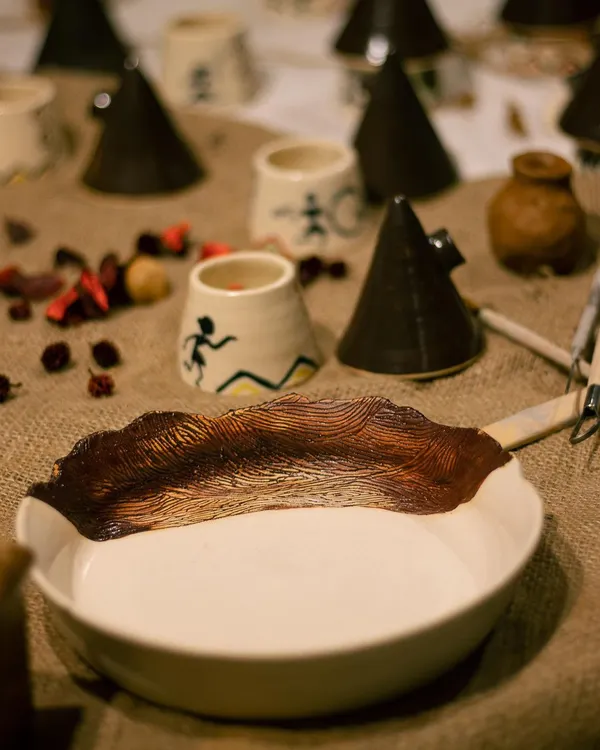 A beautiful spread of student work from our 'Glazed '22' exhibit. This shot features a stunning wave-carved serving dish, perfect for making a statement at your next dinner party.