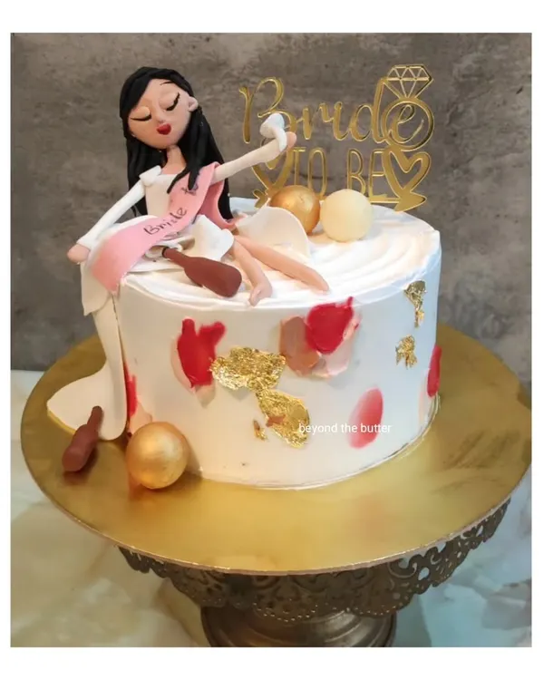 A fun and cheeky "Bride to be" cake for a bachelorette party. This design features a handmade figurine of the bride celebrating, complete with a sash and playful details.