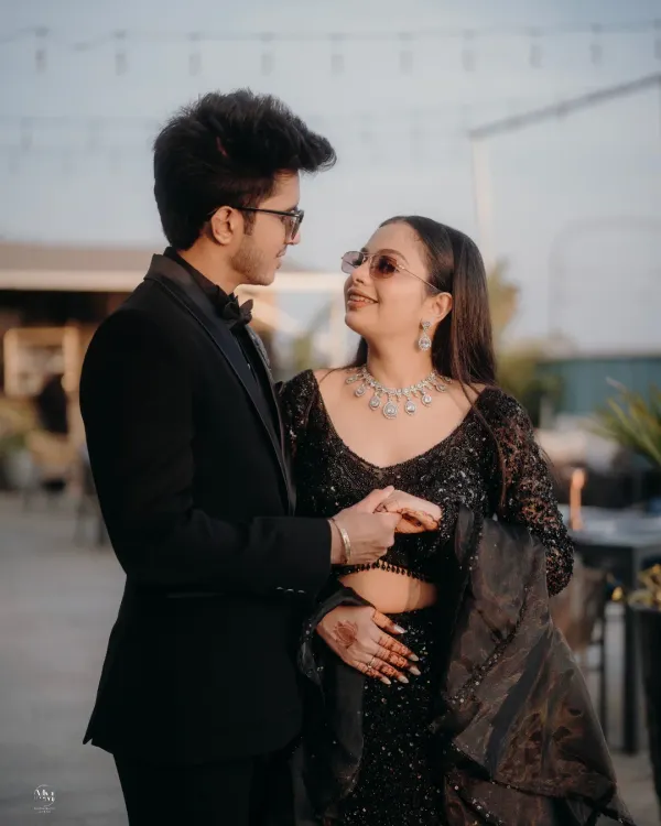 A stylish portrait of Mohit and Priyanka at their reception. Their coordinated black outfits and confident poses exude modern elegance.