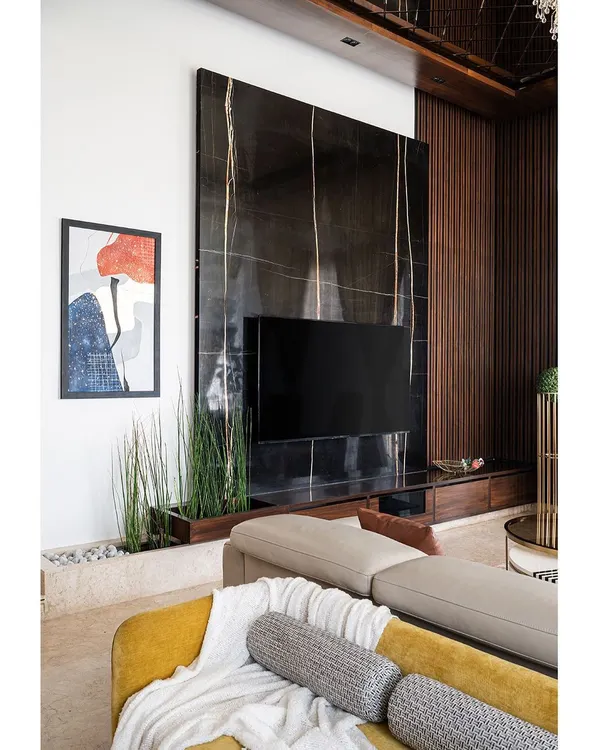 This living room, with its 14-foot ceiling and a dramatic floating TV unit made of black marble with gold inlay, is the centerpiece of a luxury Bengaluru penthouse. It embodies my approach to creating spaces that are grand yet inviting, using a mix of rich textures and a clean, modern aesthetic.