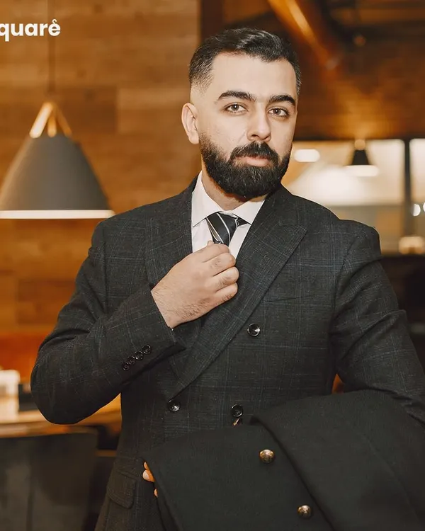 I believe a perfectly tailored suit is the cornerstone of a gentleman's wardrobe. This classic double-breasted suit, crafted from premium fabric, showcases the sharp lines and impeccable fit that define my bespoke tailoring service. It's designed to give you an air of confidence and authority.