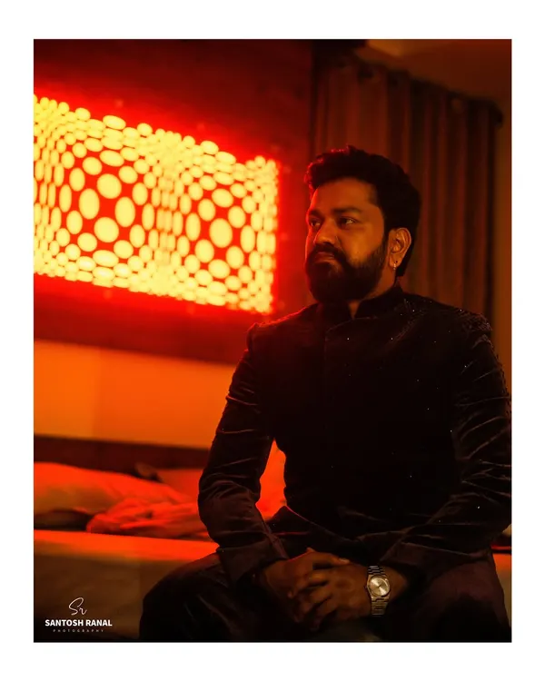 A stylish and moody portrait of the groom, captured with dramatic red lighting that creates a cinematic effect.