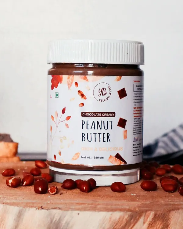 A clean and professional product shot of Yellow Bee's Peanut Butter. The focus is entirely on the jar and its label, with peanuts scattered around to hint at the ingredients. This is ideal for e-commerce listings or catalogs.