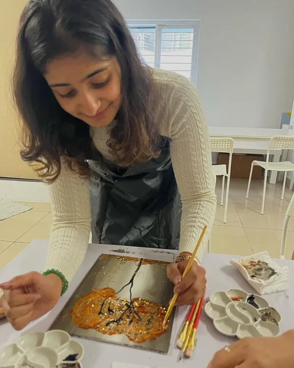 A participant adding shimmering gold foil to her painting. This technique adds a beautiful, luxurious finish to any artwork.