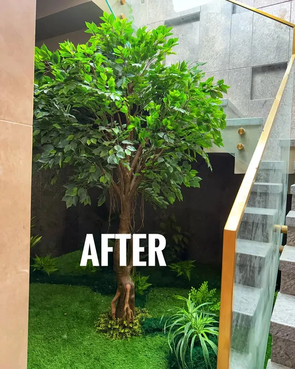 An incredible "After" shot. We transformed this empty, dark stairwell in a Vrindavan residence into a stunning green feature with a lifelike artificial Ficus tree and a bed of faux grass.