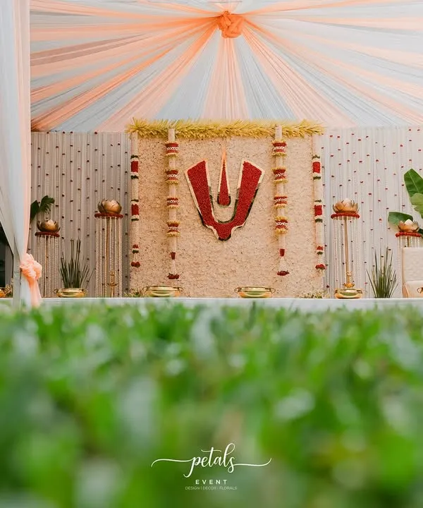 This Nalugu decor for a Telugu wedding beautifully blends tradition and elegance. The backdrop of white chrysanthemums is centered with a bold red Balaji Nama, creating a divine and auspicious atmosphere for the ceremony.