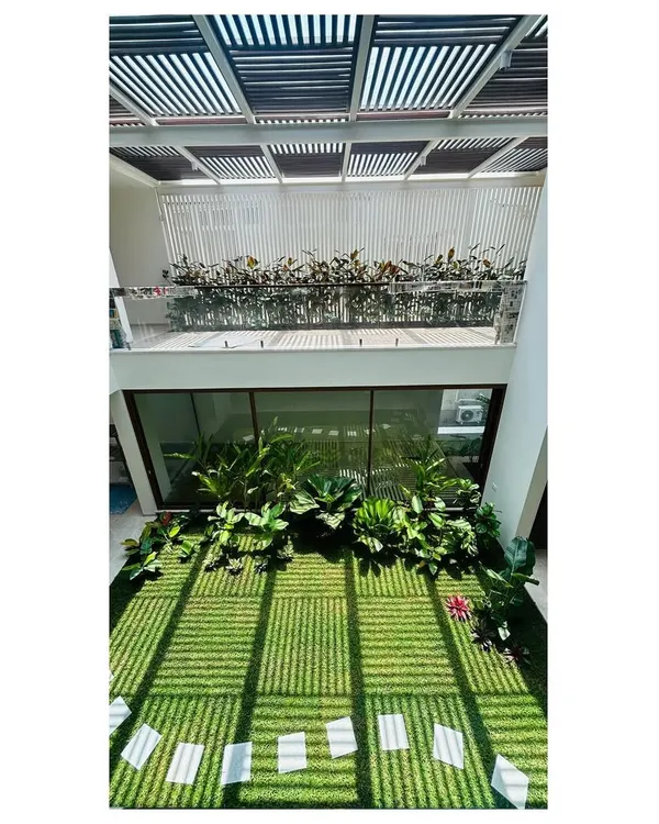 This double-height indoor courtyard in a Bangalore residence is one of our signature projects. The design allows sunlight to stream in, nourishing the lawn and tropical plants, creating a private garden that can be enjoyed from multiple levels of the home.
