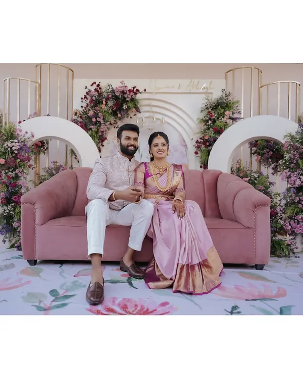 A picture-perfect moment for the newly engaged couple. I used a plush dusty rose sofa and a modern backdrop with cascading purple and pink flowers to create a romantic and stylish setting for their ring ceremony.