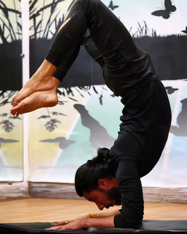 The scorpion handstand, or Vrschikasana, is an advanced inversion that requires immense strength, balance, and flexibility. Our expert instructors can guide dedicated students on the long but rewarding journey to mastering poses like this.