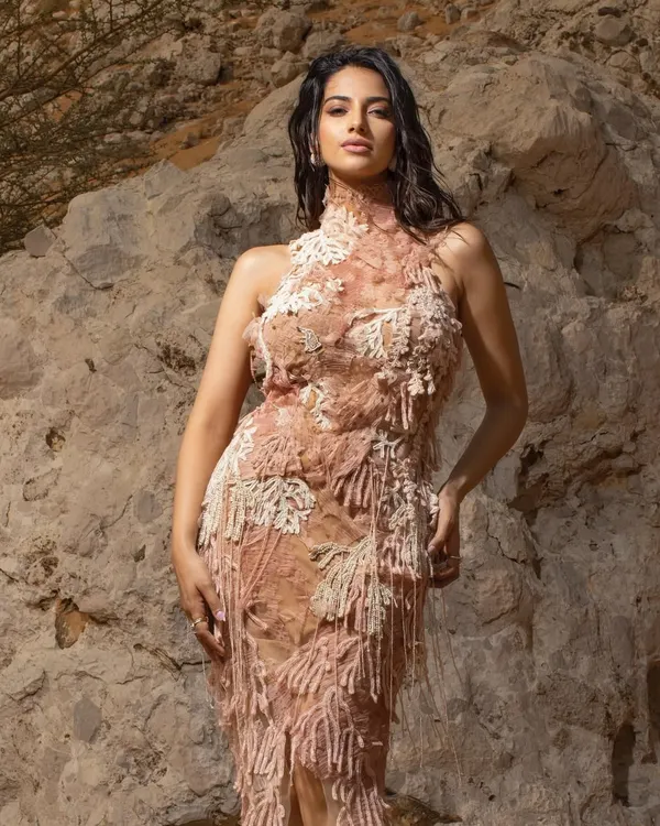 A stunning shot from a desert editorial, where the textured, earth-toned gown blends beautifully with the natural rock formations. This is an example of location-based storytelling.