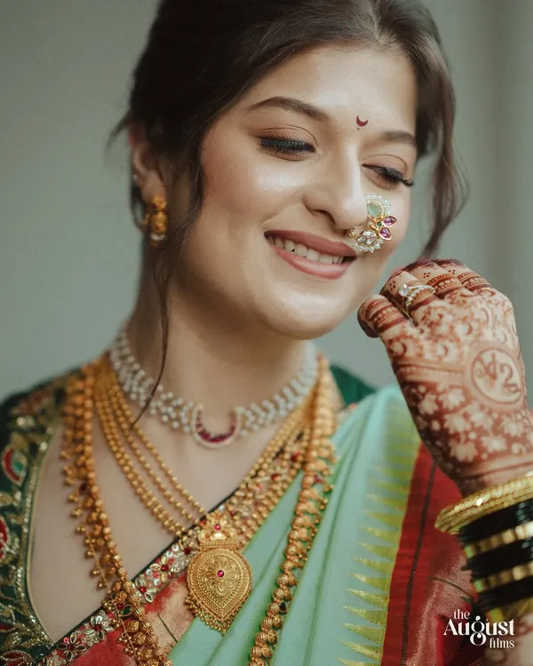 A beautiful Maharashtrian bride on her wedding day, her hair styled in a traditional updo that perfectly complements her nath and jewelry.