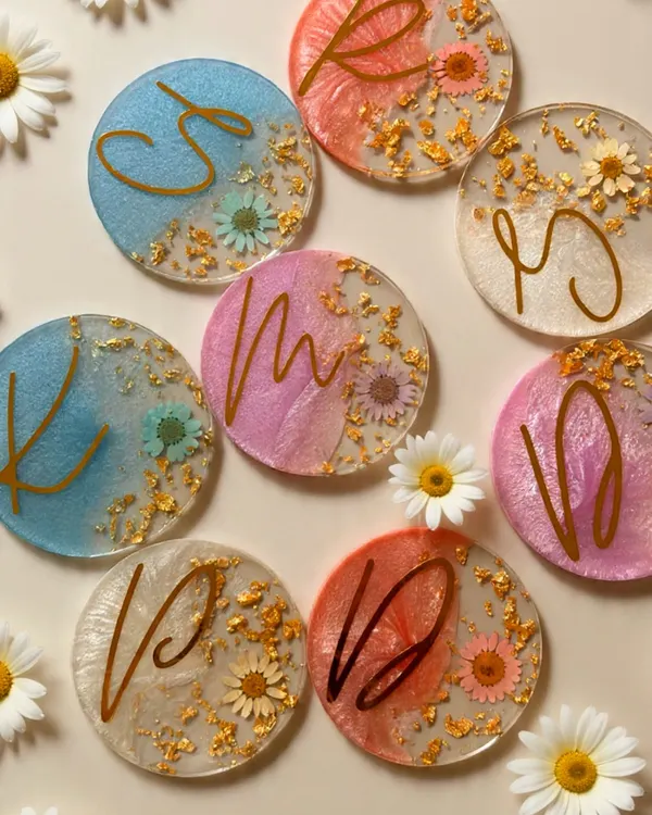 Our resin initial coasters are a beautiful and practical wedding favor. This styled shot shows how we embed dried daisies and gold flakes for an elegant, personalized touch.