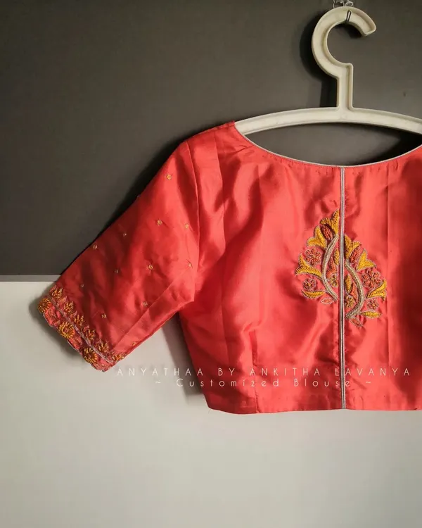 A simple yet elegant custom embroidered blouse I designed for a client. This peach silk blouse features delicate embroidery on the sleeves and a motif on the back.