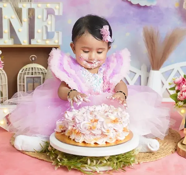 The best part of a cake smash. This little princess is digging into her first birthday cake with pure delight.