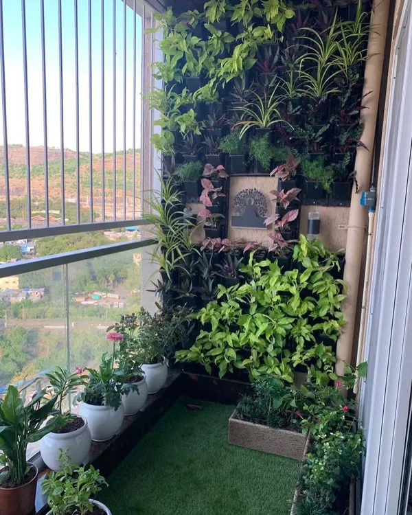 A private balcony transformed into a lush, green retreat. This vertical garden installation maximizes the small space, creating a vibrant wall of life that improves air quality and provides a beautiful city view.