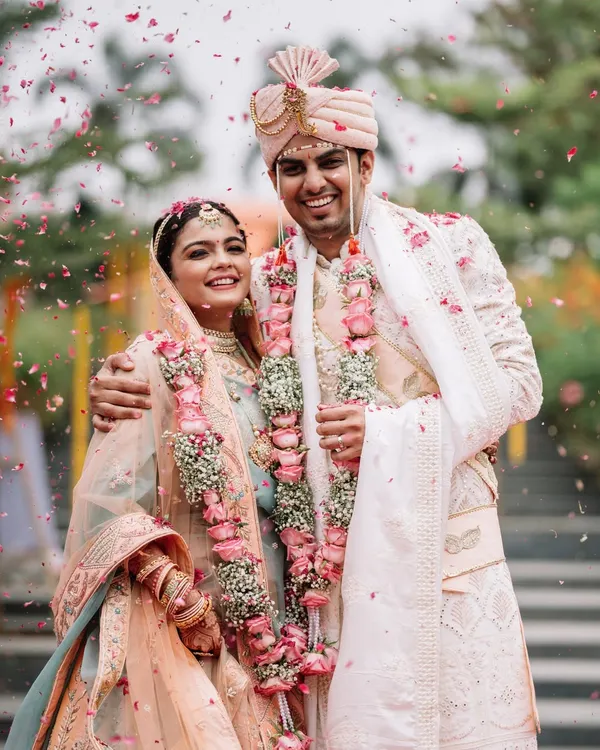 The moment right after the Varmala, with rose petals still in the air. Disha and Prateek are just beaming. This is what it's all about, capturing that pure, post ceremony glow.