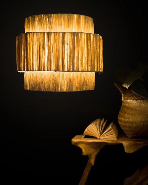 I love experimenting with different textures, and this tiered lampshade is crafted from raw natural fibers to create a rich, layered effect. When lit, it radiates a gentle, warm light that highlights the material's organic quality.
