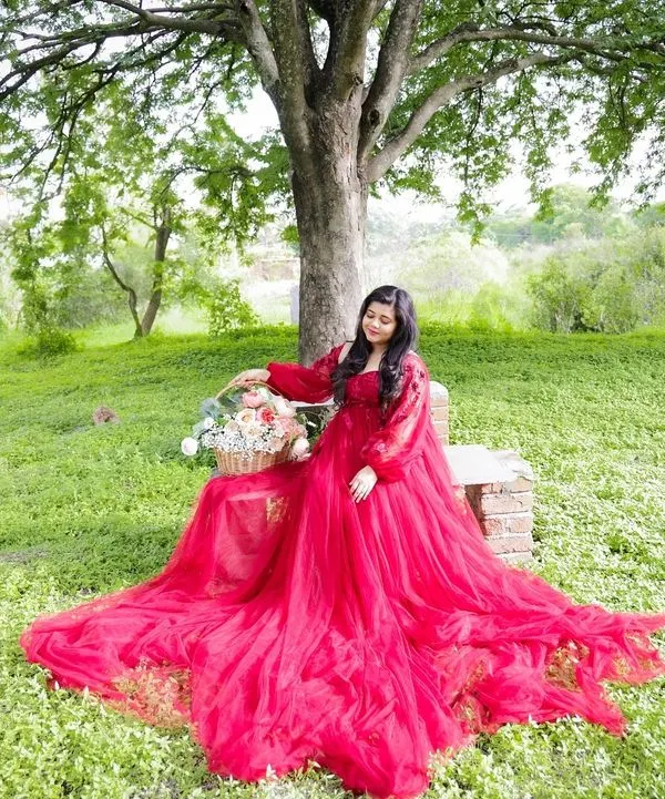 Taking the magic outdoors. This beautiful portrait was taken in a lush green park, with the vibrant red gown creating a stunning contrast against the natural scenery.