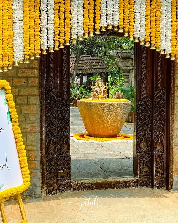 A traditional welcome to our beginning. The entrance to this heritage venue is framed by a beautiful toran of marigolds and chrysanthemums, with a matching floral border on the welcome sign.
