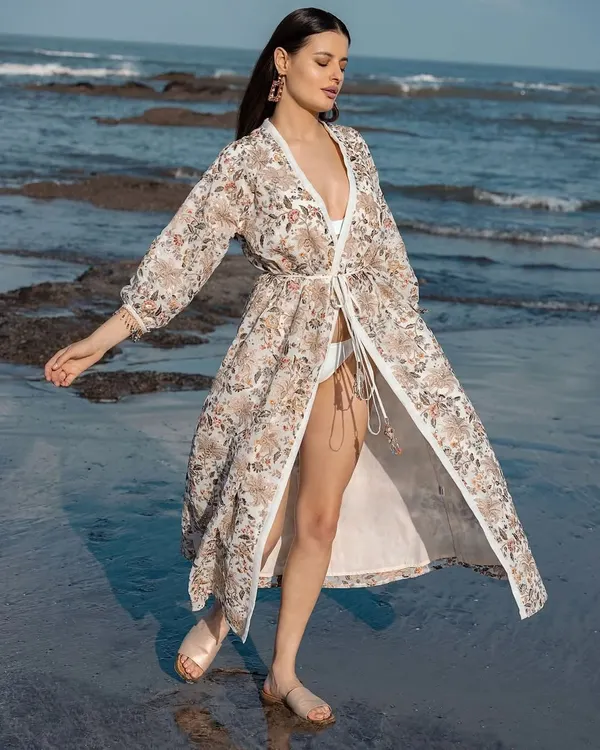 A beautiful shot of a model in a floral print kimono, styled for a resort wear brand. The look is perfect for a stylish beach day.