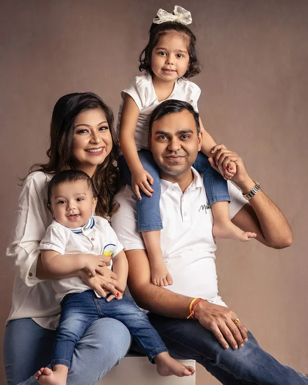 A perfect casual family portrait. Dressed in classic white and denim, this family of four radiates pure happiness and relaxed connection.