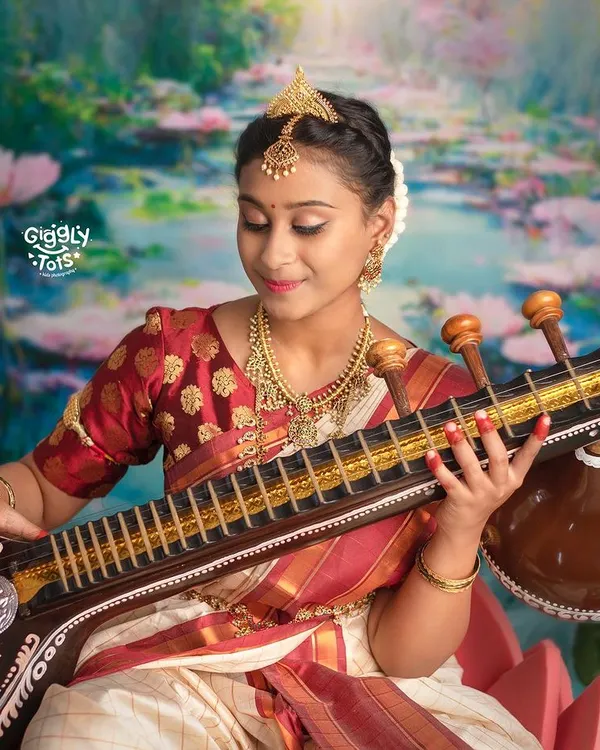 Embracing the power of Ma Saraswati through art. This close-up shot focuses on the young girl's serene expression as she plays the veena, embodying the goddess of knowledge and music.