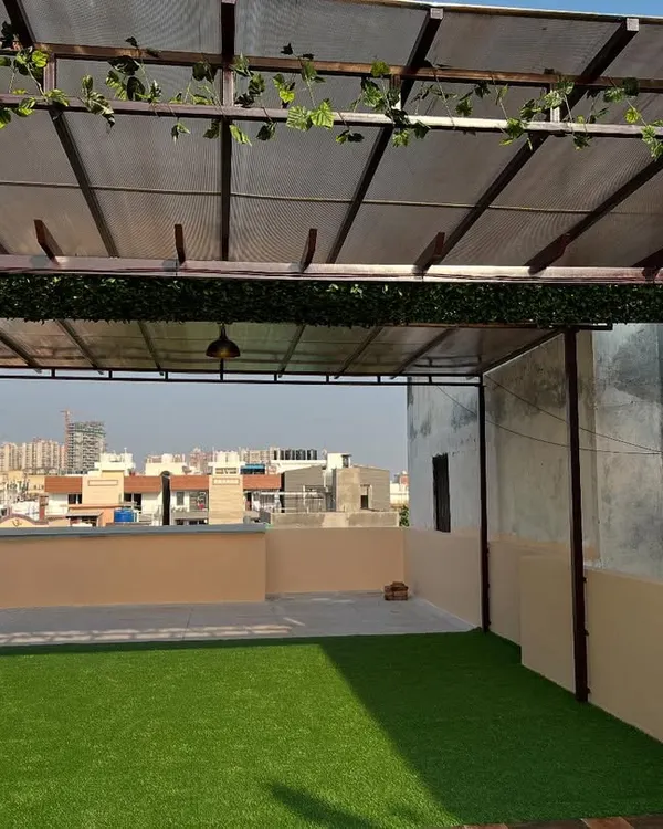 A spacious terrace converted into a usable outdoor lounge. I installed soft artificial grass and decorated the pergola beams with artificial ivy to create a relaxing, shaded environment.