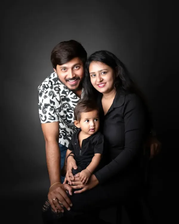 A classic family portrait against a dark backdrop. The focus is entirely on their happy expressions and the bond they share.