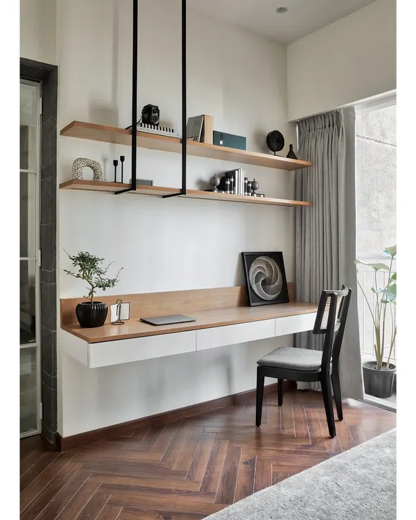 This floating study desk in white and natural oak is a perfect example of my minimalist yet functional design. The suspended open shelving keeps the space feeling light and airy, while the herringbone wood floor adds warmth and texture.