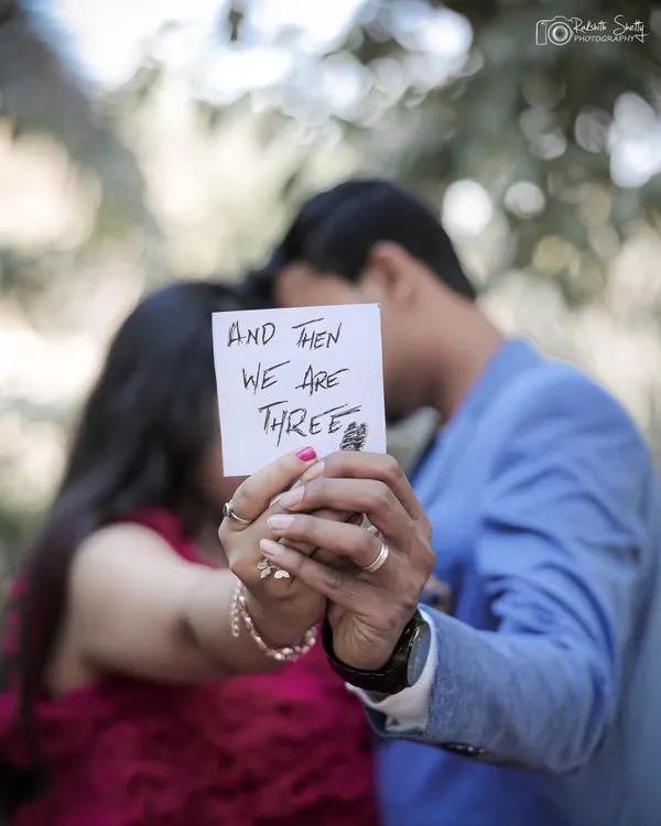 A creative announcement shot focusing on the message "And then we are three". This is a beautiful way to share your news while keeping the moment intimate.