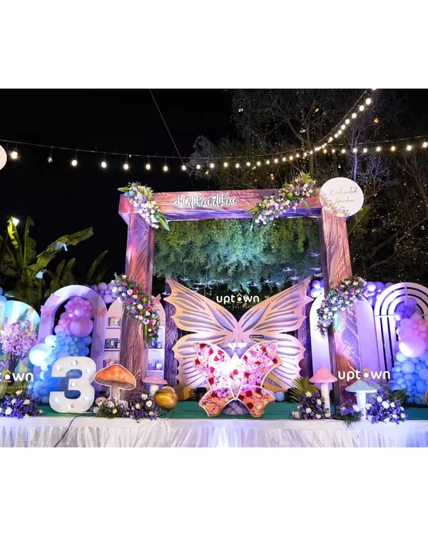 I create magical outdoor settings that bring your party theme to life. This enchanted butterfly garden birthday setup features custom props, floral arrangements, and atmospheric lighting for a truly immersive experience.