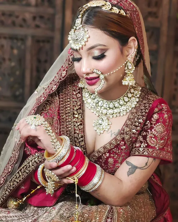This is the kind of complete, breathtaking bridal look we can create together. Notice how the oversized Polki necklace, matching maang tikka, nath, and haath phool come together to create a royal aesthetic, perfectly complementing the red bridal lehenga.