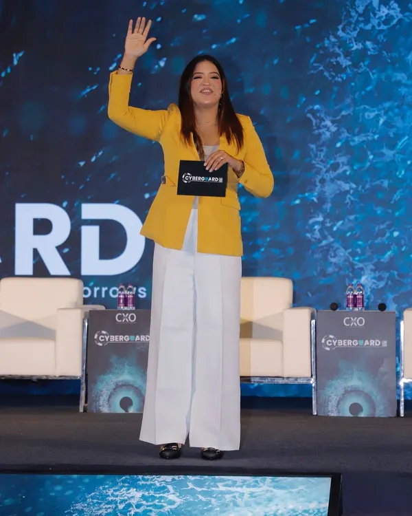 Waving to the crowd as I take the stage at the Cyberguard Summit. Hosting for the IT sector requires a sharp, energetic presence to match the innovative spirit of the industry.