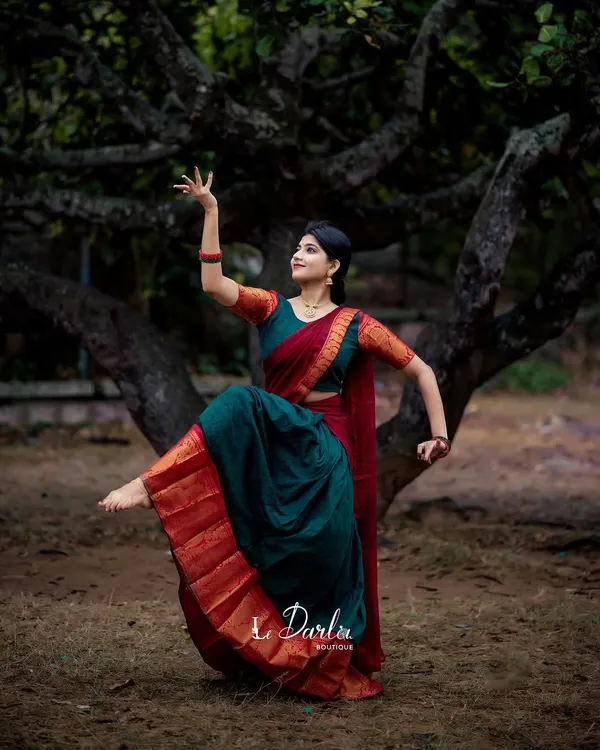 As a dancer, I find stories in movement. Here, I am modeling a traditional red and green Kanchi half-saree, using a classic Bharatanatyam pose to bring a sense of timeless grace and energy to the garment.