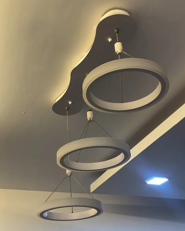 Installation of a contemporary three-ring LED pendant light. This type of modern chandelier is perfect for living rooms or dining areas, and I ensure it's hung securely and wired correctly for optimal performance.