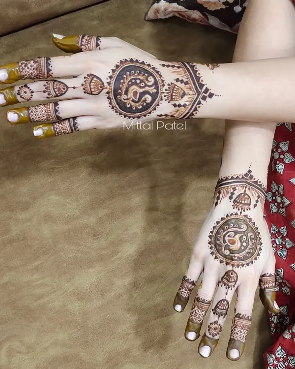 This minimalist design features a central mandala with a peacock inside, paired with delicate finger details. It's a perfect example of how traditional motifs can be used in a modern, uncluttered way.