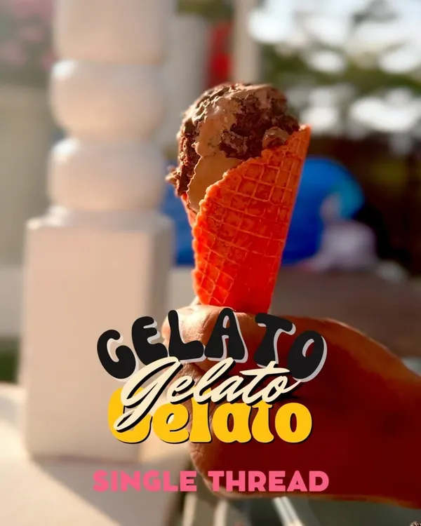 A perfect scoop of our handcrafted gelato served in a vibrant red waffle cone. This image captures the simple joy of a high-quality, delicious dessert, perfect for any occasion.