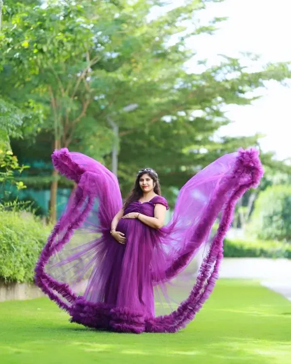 This dramatic outdoor portrait with a flowing purple trail gown is a client favorite. The 'flying dress' effect creates a truly memorable and powerful image, perfect for celebrating your pregnancy journey.