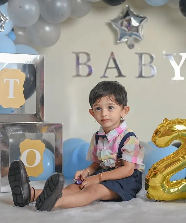Celebrating the big TWO! This birthday setup features a balloon arch and letter blocks spelling out 'TWO'. It's a fun and festive way to capture your toddler's personality as they celebrate their second birthday.