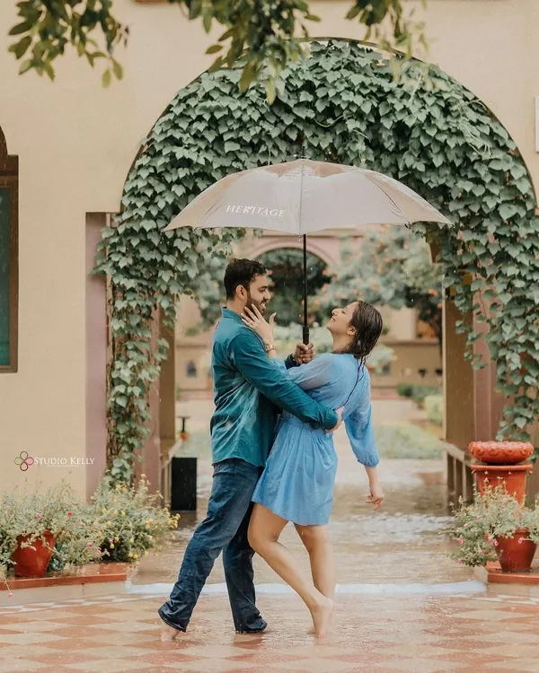 A classic Bollywood-style romance shot in the rain. The couple shares an umbrella and a dance, creating a moment that is both playful and deeply romantic.