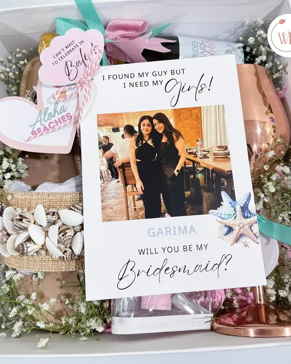 The ultimate bridesmaid proposal box for a destination bachelorette in Bali. It includes a personalized card, shell-decorated flip-flops, a custom wine glass, and other themed goodies.