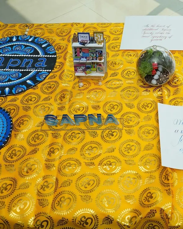 A beautiful display of crafts from our various workshops, including intricate Mandala art and a miniature bookshelf, showcasing the diverse skills we teach.