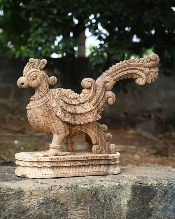 An exquisitely carved wooden parrot statue with a natural finish. In Hindu tradition, the parrot symbolizes truth and love, making this a beautiful and meaningful decorative piece.
