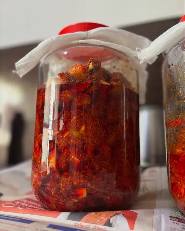 This is my classic homemade mango pickle, slowly maturing in a traditional glass jar. I make it just once a year using fresh, raw mangoes and a family recipe, ensuring an authentic taste without any artificial preservatives.