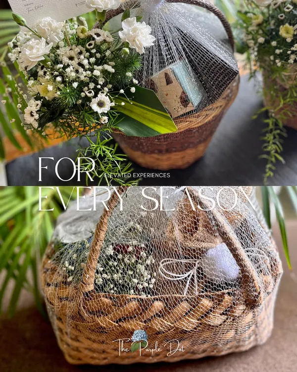 A duo of curated hampers perfect for any season. The top basket features fresh white carnations, while the bottom one is filled with gourmet nuts, both elegantly wrapped in netting to showcase the contents.